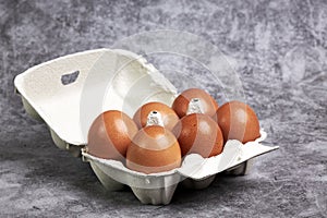 Carton box with half a dozen fresh brown eggs. Healthy food