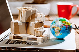 Carton boxes on computer as online shopping logistics concept