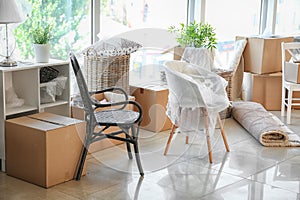 Carton boxes and interior items on floor in room. Moving house concept