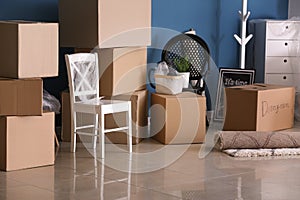 Carton boxes and interior items on floor in room. Moving house concept