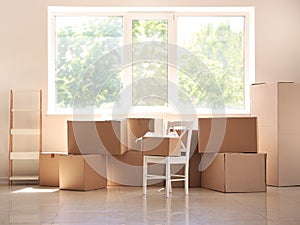 Carton boxes and interior items on floor in room. Moving house concept