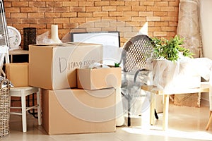 Carton boxes and interior items in room. Moving house concept