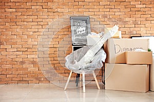 Carton boxes and interior items in room. Moving house concept