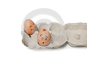 Carton of brown eggs with one cracked egg