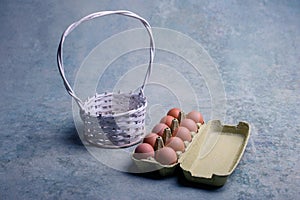 A carton of a dozen fresh eggs and white basket