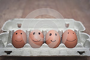 Carton of eggs with kids drawings of face of family in black pen with happy expressions