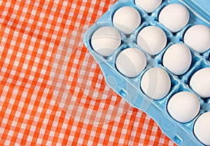 Carton of Eggs on Rustic Table With Checkered Table Cloth