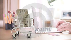 Cartons with GAP logo in shopping cart near computer. Editorial online store order related 3D rendering