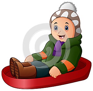 Cartoon boy in green winter clothes playing a sledge