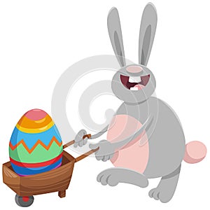 Cartoon Easter bunny with big egg on wheelbarrow