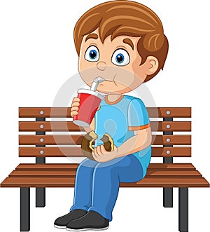 Cartoon little boy eat donut and drink soda on bench