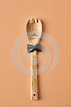 Cartoon man with a mustache from farfalle pasta and wooden spoon, conceptual photography for food blog or ad