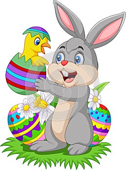 Cartoon rabbit holding a baby chick hatching from an Easter egg