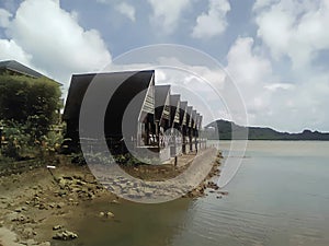 Cartoon style picture of wooden houses in traditional Palauan style on the ocena coast in Koror, Palau.