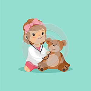 Cartoon toddler girl playing doctor, examining her plush teddy bear toy with stethoscope. Flat design baby character in