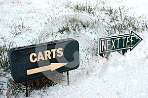 Carts and next tee sign on a snow golf course