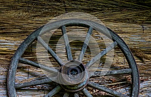 Cartwheel at the old sraw wall of a house