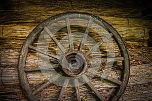 Cartwheel at the old sraw wall of a house