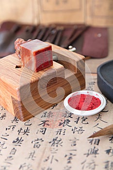 The carved bed and carved seal, inkstone and ink pad on the background of Chinese calligraphy writing