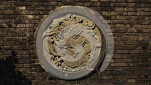 A carved Chinese dragon out of stone on a wall within Hong Kong China.