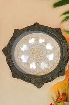 Carved circle window in brahma vihara arama buddhist temple, bali, indonesia. Stone carved of circular window in a