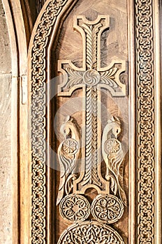 Carved cross on the front wooden door in the Church
