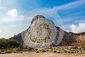 Carved golden buddha image on the cliff at Khao Chee Jan, Pattaya, Thailand