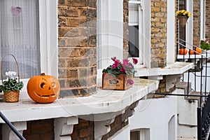 Carved halloween pumpkins displayed on the windowsills of terraced London town houses photo