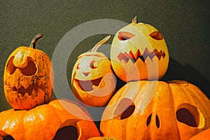 Carved halloween pumpkins on green background.