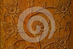 Carved pattern of flowers on the old wooden door