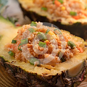 Carved pineapple stuffed with fresh pineapple tomato sauced seafood fried rice