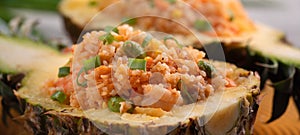 Carved pineapple stuffed with fresh pineapple tomato sauced seafood fried rice