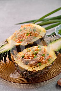 Carved pineapple stuffed with fresh pineapple tomato sauced seafood fried rice