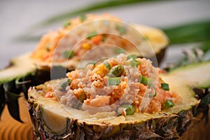 Carved pineapple stuffed with fresh pineapple tomato sauced seafood fried rice