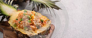 Carved pineapple stuffed with fresh pineapple tomato sauced seafood fried rice