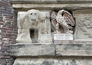 Carved stone eagle sculpture on the front facade of the d\'Accursio Palace in Bologna, Italy.