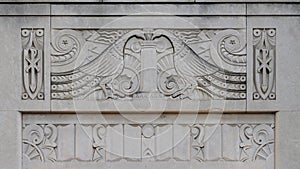 Carved stone relief of two peacocks drinking from a vase above an outside entrance to Christ the King Catholic Church in Dallas