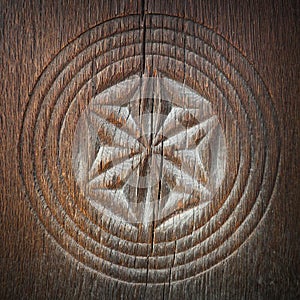 Carved symbol on ancient wood