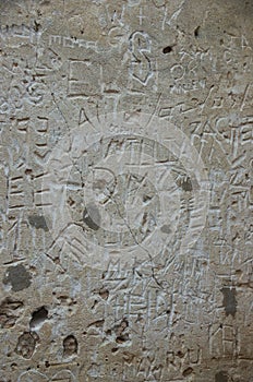 Carved wall graffiti in historic ruin