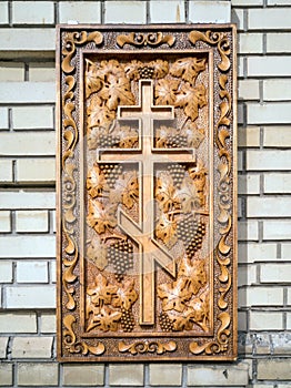 Carved wooden Orthodox cross and bunches of grapes. The concept of religion.