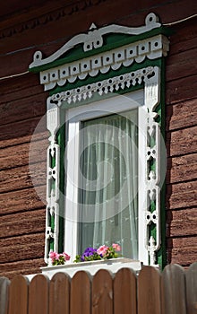 Carved wooden platband on window of old wooden house, Kostroma, Russia