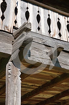 Carved wooden railing detail to rustic old house