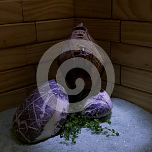 Carved wooden statue of a gnome with lantern resting over granite stones