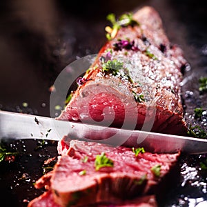 Carving a portion of rare roast beef