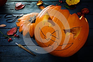 Carving a pumpkin for halloween, tinker autumn decoration on a b