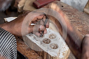 Carving a wooden printing block for textile block printing photo