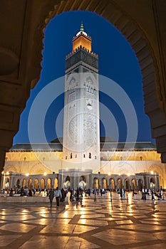 CASABLANCA, MOROCCO- JUNE, 8, 2019: dusk view of the minaret of hassan ii mosque framed by an arch in casablanca