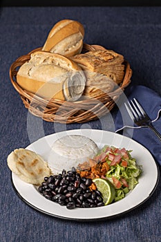 Casado, typical Costa Rican dish with rice, beans and vegetables on a table with blue tablecloth