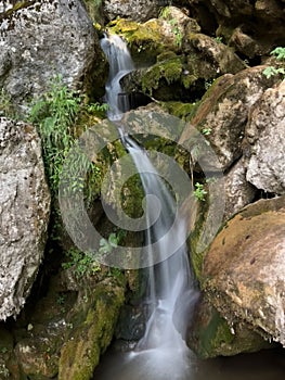 Cascade falls over mossy rocks at the Myrafaelle (myrafalls) hiking trail