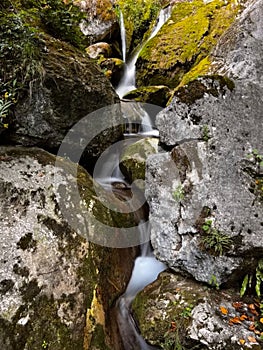 Cascade falls over mossy rocks at the Myrafaelle (myrafalls) hiking trail